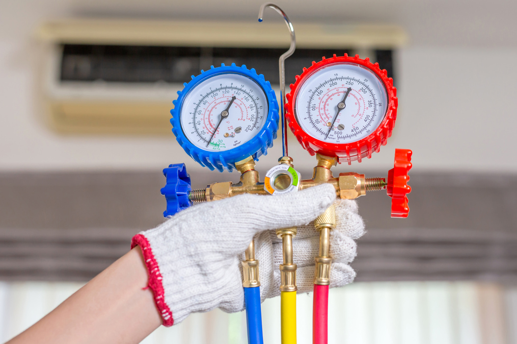 Air Conditioning Repair, Repairman Holding Monitor Tool to Check